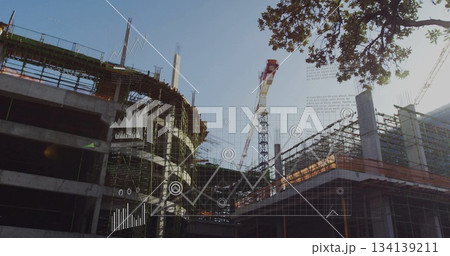 Showing tower crane and scaffolded concrete structure with rebar at job site, with digital overlays Showing tower crane and scaffolded concrete structure with rebar at job site, with digital overlays 134139211