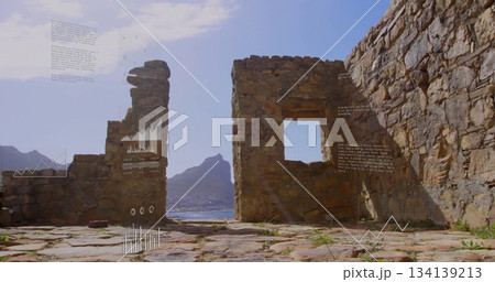 Framing crumbling stone wall showing ruins on coastal ledge featuring window opening and sea view 134139213