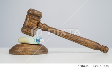 Judge's gavel hits e-cigarette. Smoking ban. Tobacco heating systems. Judge's gavel hits e-cigarette. Smoking ban. Tobacco heating systems. 134139430