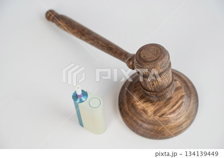 Judge's gavel and electronic cigarette. Smoking ban. Tobacco heating systems.  134139449