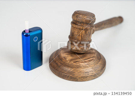 Judge's gavel and electronic cigarette. Smoking ban. Tobacco heating systems.  134139450