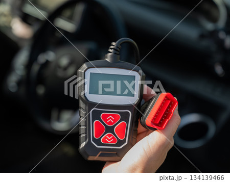 Woman using OBD2 diagnostic scanner. Woman using OBD2 diagnostic scanner. 134139466