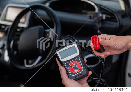 Woman using OBD2 diagnostic scanner.  134139542
