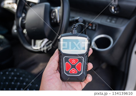 Woman using OBD2 diagnostic scanner. Woman using OBD2 diagnostic scanner. 134139610