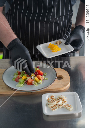 The chef lays out the salad. The chef lays out the salad. 134139643