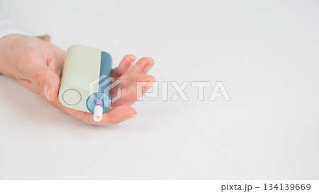 Woman holding electronic cigarette on white background. Tobacco heating systems. 134139669