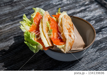 Homemade salmon flatbread on a table in a cafe. Homemade salmon flatbread on a table in a cafe. 134139696