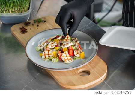 The chef lays out the salad. The chef lays out the salad. 134139759