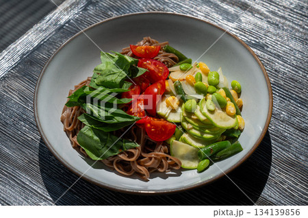Top view of a dish of buckwheat noodles with vegetables.  134139856