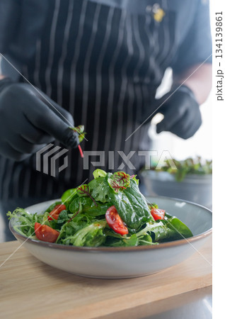 The chef prepares a salad. The chef prepares a salad. 134139861