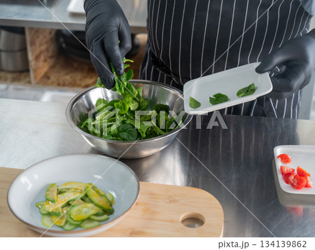 The chef prepares a salad. The chef prepares a salad. 134139862
