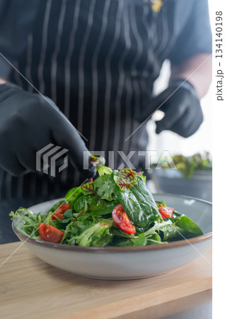 The chef prepares a salad. The chef prepares a salad. 134140198