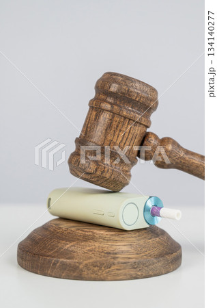Judge's gavel hits e-cigarette. Smoking ban. Tobacco heating systems.  134140277