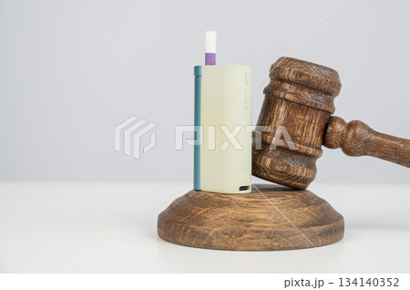 Judge's gavel and e-cigarette. Smoking ban. Tobacco heating systems.  134140352