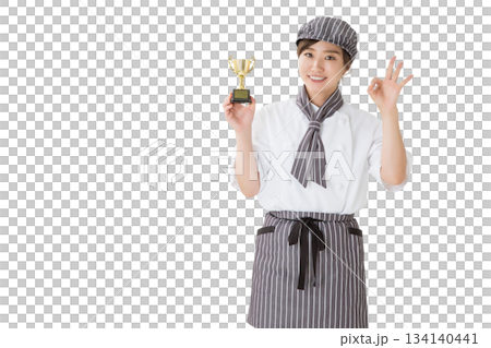 一位身穿廚師服的女子手捧獎杯 一位身穿廚師服的女子手捧獎杯 134140441