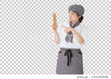 A woman wearing a chef's coat holding a thermometer A woman wearing a chef's coat holding a thermometer 134140446