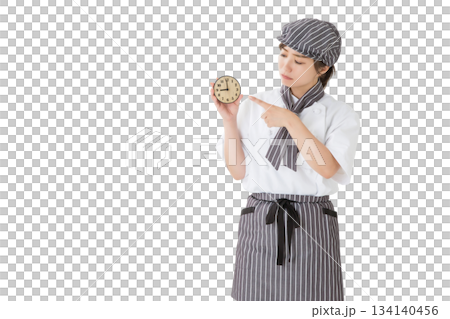 一位身穿廚師服的女子拿著一個鐘錶 一位身穿廚師服的女子拿著一個鐘錶 134140456