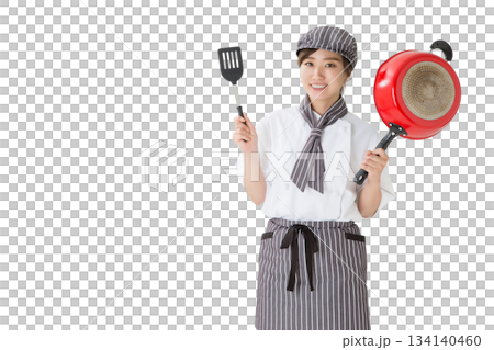 A woman wearing a chef's coat holding a frying pan A woman wearing a chef's coat holding a frying pan 134140460