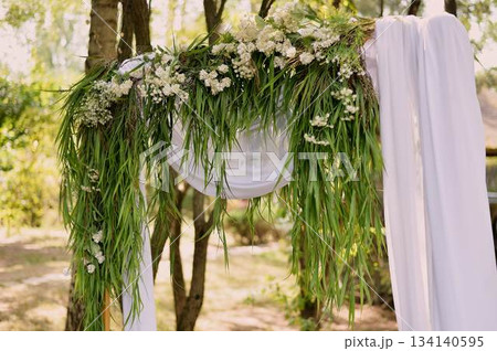 Arch for off-site registration. White chiffon and grass. Outdoor wedding. 134140595