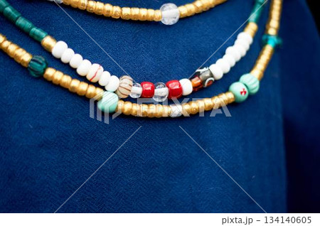 Beads in the old style against the background of blue linen fabric. Vikings, Slavs. Pastiche. Beads in the old style against the background of blue linen fabric. Vikings, Slavs. Pastiche. 134140605