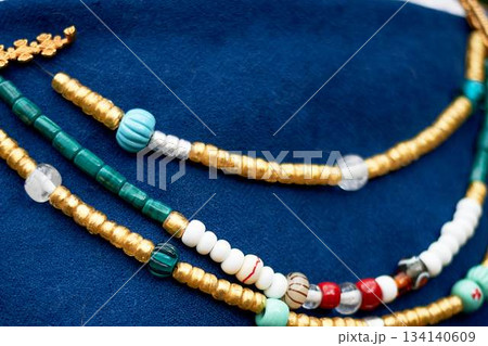 Beads in the old style against the background of blue linen fabric. Vikings, Slavs. Pastiche. 134140609