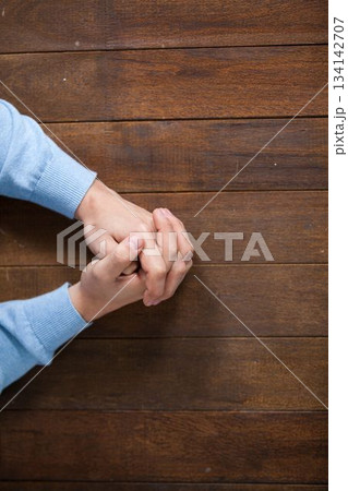 Man praying on wooden table Man praying on wooden table 134142707