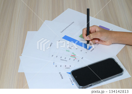 スマートフォンとビジネス資料をチェックする手元 134142813