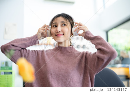 Asian businesswoman office worker holding a pen under chain looking at laptop on table in white room Asian businesswoman office worker holding a pen under chain looking at laptop on table in white room 134143157