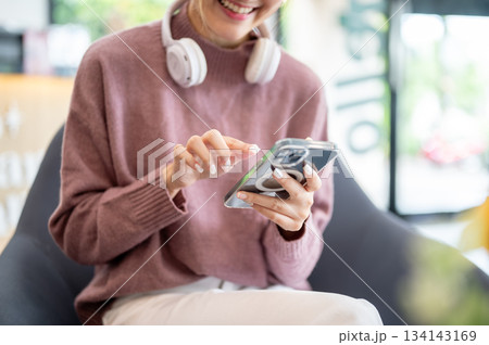 Asian businesswoman office worker holding a pen under chain looking at laptop on table in white room Asian businesswoman office worker holding a pen under chain looking at laptop on table in white room 134143169