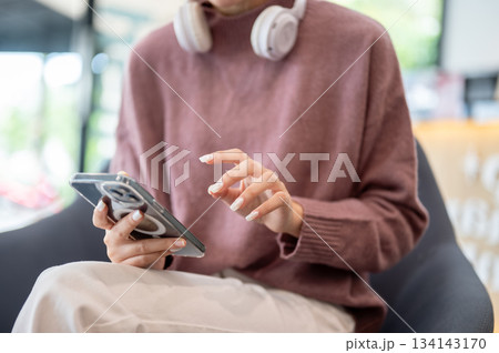 Asian businesswoman office worker holding a pen under chain looking at laptop on table in white room Asian businesswoman office worker holding a pen under chain looking at laptop on table in white room 134143170