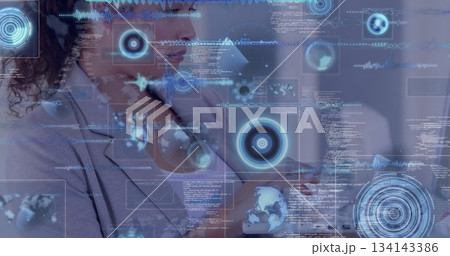 Interacting professional woman holding hand up in corporate office, with floating HUD graphics Interacting professional woman holding hand up in corporate office, with floating HUD graphics 134143386