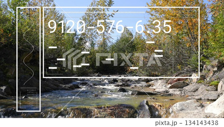 Flowing stream passing over rocks in mountain forest, with UI panel, code and binary digits 134143438