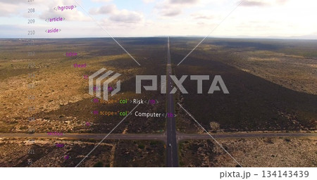 Stretching two-lane road cutting through plain in drone view, with shrubs and HTML or XML code overl Stretching two-lane road cutting through plain in drone view, with shrubs and HTML or XML code overl 134143439