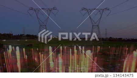 Creating vertical colored light streaks across steel towers, power lines in grassland with dusk sky 134143475
