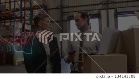 Warehouse staff in business attire scanning stock boxes using scanner and laptop at warehouse 134143509