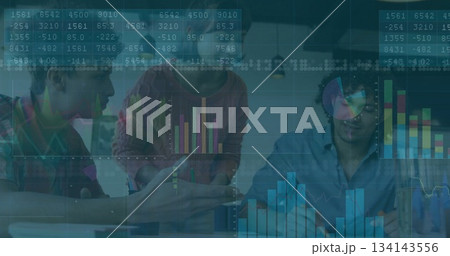 Collaborating data analysts interpreting analytics in modern office with laptop papers coffee mugs 134143556