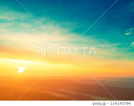 Beautiful dramatic evening sky over pine forest. Village in the forest during sunset. Aerial view 134143794