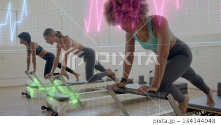 Woman wearing teal sportswear performing pilates workout on reformer in pilates studio, copy space 134144048
