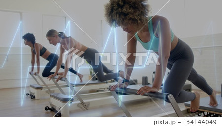 Holding plank sportswear-clad woman on reformer at Pilates studio, fitness tracker, copy space Holding plank sportswear-clad woman on reformer at Pilates studio, fitness tracker, copy space 134144049