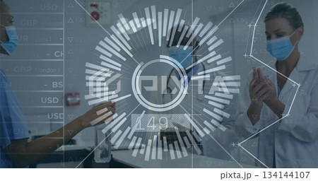 Three masked professionals sanitizing hands in hospital with sanitizer dispenser and stethoscope 134144107