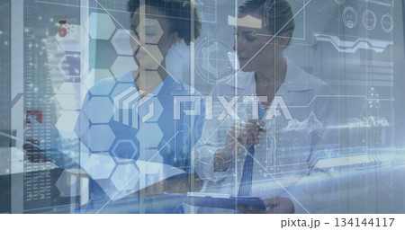 Doctor and nurse in medical attire reviewing records in clinic, with clipboard, holographic overlay 134144117