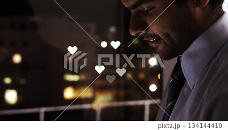 Standing employee wearing shirt and tie gazing at window in office, rising heart icons, copy space Standing employee wearing shirt and tie gazing at window in office, rising heart icons, copy space 134144410