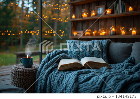 This image captures a cozy reading nook beside a rain-streaked window, perfect for relaxation on a rainy day. 134145175