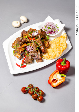 Top view of braised ribs with potatoes and onions on grey background - appetizing dish 134145332