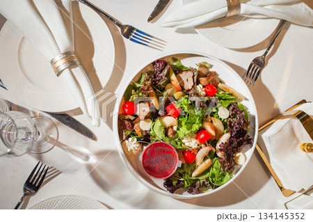 Top view of salad with chicken, nuts and cherry tomatoes - appetizing dish on white background 134145352