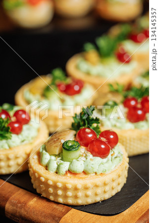 Savory tartlets with creamy filling and vibrant toppings Savory tartlets with creamy filling and vibrant toppings 134145357