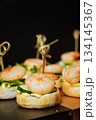 Close-up of canape with shrimp and cucumber on dark background - elegant appetizer 134145367