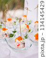 Close-up of canape with red caviar in glass dish on white background - luxurious appetizer 134145429