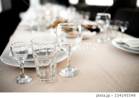 Restaurant. A table set for dinner. Cutlery, glasses and napkins on a table covered with a white tablecloth 134145549