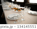 Restaurant. A table set for dinner. Cutlery, glasses and napkins on a table covered with a white tablecloth 134145551